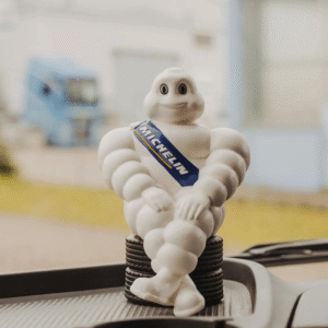 Michelin figure sitting on car tires placed on a dashboard.